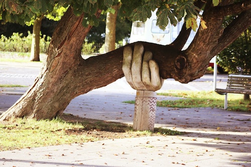 Tree supported by carved hand